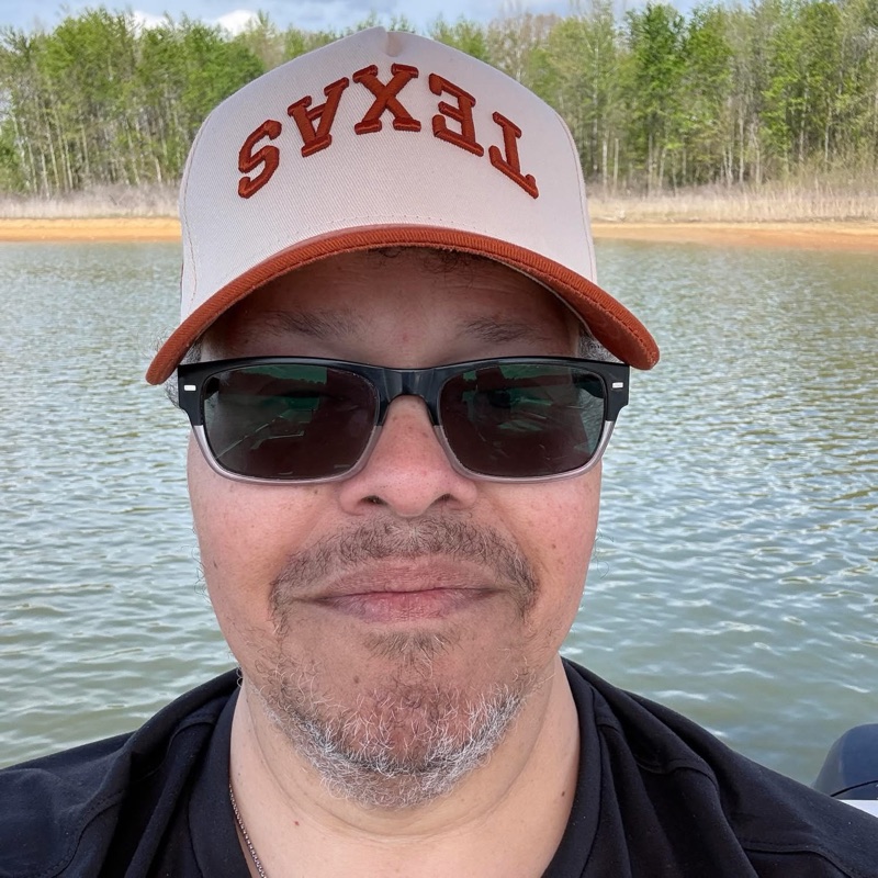 Ed Hardeman on the lake in a cream and rust cap and sunglasses